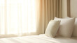 © Big - Hotel bed with crisp white linens and decorative pillow in soft morning light through sheer curtains.