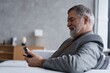 © opolja - Mature smiling man using smartphone
