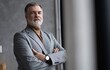 © opolja - Portrait of a confident mature businessman near the window.