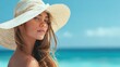 © DSimage - Young woman in straw hat posing at tropical beach with turquoise sea and clear blue sky in the background.