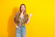 © deagreez - Young chic woman in floral top and jeans smiles against a bright yellow background