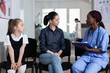 © DC Studio - African american doctor explaining daughter health status to young mother. Adult woman, little girl in consultation at children hospital. Pediatrician attending young child sister.