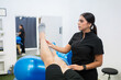 © Carlos Flores - Physiotherapist assisting man with leg rehabilitation exercise