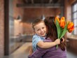 © BillionPhotos.com - Cute happy Child congratulating mom giving flowers.