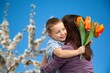 © BillionPhotos.com - Happy woman and child hold flowers. Mothers day