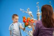 © BillionPhotos.com - Happy woman and child hold flowers. Mothers day