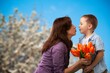 © BillionPhotos.com - Happy woman and child hold flowers. Mothers day