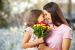 © BillionPhotos.com - Happy woman and child hold flowers. Mothers day