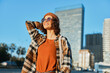 © SHOTPRIME STUDIO - Woman with smile in urban scene wearing sunglasses and beanie and plaid jacket, joyful candid moment in golden hour glow, authenticity and mindful living captured in emotional storytelling.