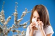 © BillionPhotos.com - Brunette girl sneezing in a tissue on spring background