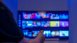 © di-photo - Watching streaming apps on smart tv with remote control