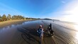 © Jeff - First-person perspective of friends cycling on the vast sandy shoreline of Chesterman Beach at low tide in Tofino