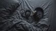 © Omishu Makes - Close-up of professional headphones on dark grey rumpled cotton sheets, creating a cozy moody atmosphere.