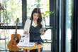 © apichat - Woman entrepreneur analyzing business market data in cafe