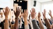 © DWI - Diverse group of people raising hands in a meeting or conference.