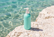 © AI Entertainment - Flacone turchese con pompa su roccia vicino al mare