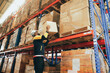 © ฺฺฺBoonterm - Male workers strength lift heavy boxes merchandise on their shoulders move them  distant shelves and risk injury or accidents from repeatedly lifting heavy items without weight lifting equipment.