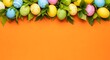 © Brishy  - A vibrant display of colorful Easter eggs surrounded by lush green leaves on a bright orange background viewed from directly above