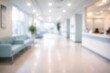 © BhansaliKushal - Blurred abstract background of modern hospital or clinic waiting area with light blue sofas and reception desk, showcasing a clean and bright medical facility interior.