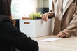 © Pormezz - Unemployment ,jobless crisis, worker layoff concept, Close-up of young businessman pack stuff off the desk and holding boxes of self stuff when quitting the job after send resign letter from company