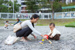 © leungchopan - Baby and mum playing with pebble stones at park