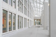 © K - Contemporary indoor walkway under glass canopy with repeating window grid, clean public corridor for office, hospital, or retail facility branding