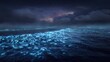 © afridwi - Ocean waves illuminated by glowing light under a starry night sky