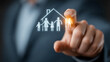 © qazi - Business professional touching glowing happy family home icon on transparent digital screen in modern living room setting, representing family security planning strategy