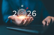 © Nirusmee - Businessman planning 2026 business goals with digital target icon, representing strategic planning, innovation, growth strategy, and future success in finance and AI-driven business development.