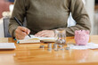 © David - An individual engages in detailed budgeting with coins laid out alongside a piggy bank and notebook, emphasizing a proactive approach toward financial management.