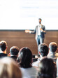 © kasto - Speaker giving a talk in conference hall at business event. Rear view of unrecognizable people in audience at the conference hall. Business and entrepreneurship concept
