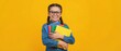 © ABSTRACTARTWORK - Cheerful young student holding colorful school supplies bright yellow background portrait indoor setting smiling expression emphasizing education and learning