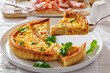 © myviewpoint - Slice of Quiche Lorraine on a spatula on a plate