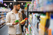 © Serhii - Man choosing cleaning supplies in supermarket aisle