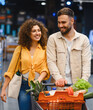 © Serhii - Happy couple enjoying grocery shopping in supermarket aisle