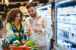 © Serhii - Couple checking grocery receipt while shopping in supermarket