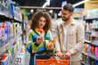 © Serhii - Couple comparing cleaning products in supermarket aisle