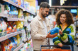 © Serhii - Couple shopping for laundry detergent in supermarket aisle