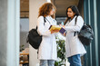 © Serhii - Medical students discussing study notes in university corridor