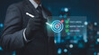© Vactzone - Business goal setting concept with businessman using digital stylus to target center of dartboard, symbolizing strategic planning, objective alignment, achievement checklist for organizational success