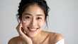 © ruangrit19 - Radiant Asian Woman Applying Skincare Cream for a Healthy and Glowing Complexion Beauty Treatment Self Care.