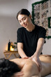 © wedmoments.stock - Professional massage therapist giving relaxing back massage to woman in wellness spa setting.