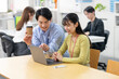 © M - オフィスでノートパソコンを見ながら笑顔で打ち合わせするビジネスパーソン　女性社員