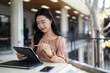 © snowing12 - Asian woman working digital tablet stylus outdoor cafe balcony remote working online study freelancer creative project student technology