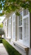 © Pixelzone - Elegant exterior home design with white louvered window shutters