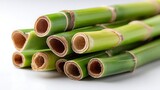 A stack of fresh green bamboo stalks with visible nodes and hollow interiors on a white background