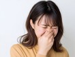 © Jumpei - 鼻をつまんで嫌な臭いに顔をしかめる不快そうな表情をした茶髪の若い女性の上半身