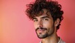 © Viktor - Young man with curly hair and beard smiles. He has brown eyes and wears a light shirt. Colorful pink and orange background creates a vibrant mood.