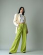 © Maryna - Young Asian woman wears stylish outfit. Light blazer, white top, green wide-leg pants. Poses confidently with hands in pockets. Pro studio portrait.