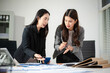 © laddawan - Two businesswoman discuss investment project working and planning strategy with tablet laptop computer in office.